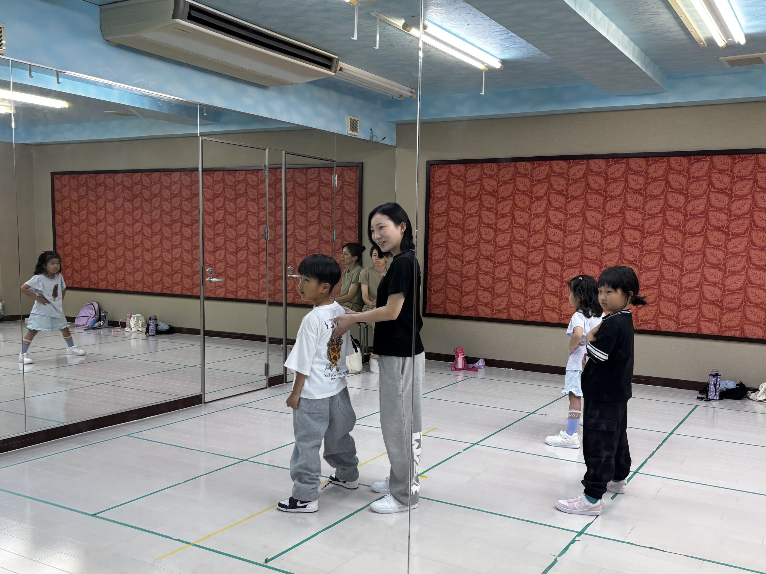 小牧市の初心者向けダンス教室で小学生の生徒に優しく声をかけるインストラクター